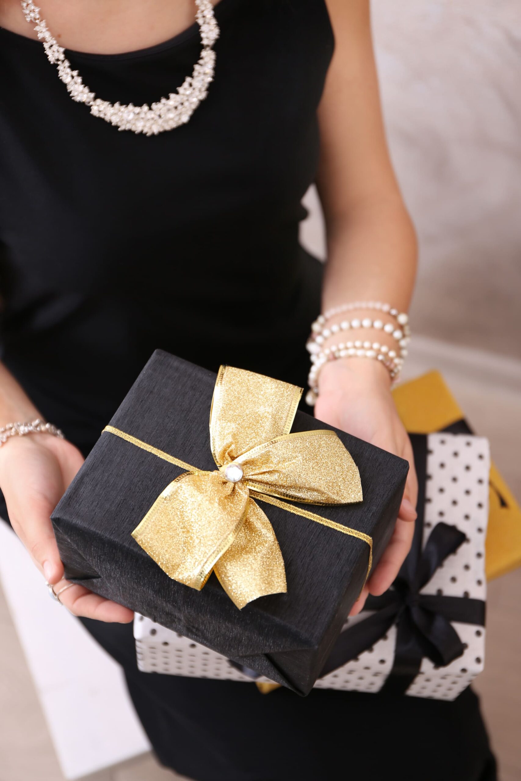Eine elegante Frau hält ein Geschenk in den Händen.